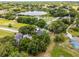 An aerial view shows a neighborhood surrounding a lake and lush trees at 333 Sonoma Valley Cir, Orlando, FL 32835