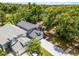 Aerial view of home showing long driveway, mature trees, and neighbor properties near wooded reserve at 333 Sonoma Valley Cir, Orlando, FL 32835