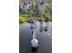 Aerial view of the gazebo sitting on a pier in the middle of the lake, in a community with manicured lawns at 3446 Soho St # 108, Orlando, FL 32835
