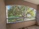 Screened balcony featuring scenic views of lush trees and well-maintained landscaping at 3446 Soho St # 108, Orlando, FL 32835