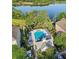 Aerial shot of a community pool featuring lounge chairs and a hot tub, nestled near a serene lake at 3446 Soho St # 108, Orlando, FL 32835