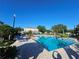 Exterior shot of a refreshing community pool with lounge chairs and lush landscaping at 3446 Soho St # 108, Orlando, FL 32835