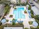 Aerial view of a community pool with lounge chairs, gazebos, and lush landscaping at 3446 Soho St # 108, Orlando, FL 32835