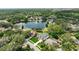 Overhead view of a home with a pool, expansive yard, mature trees, and a peaceful pond in a residential area at 3534 Woodley Park Pl, Oviedo, FL 32765