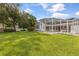 A well-maintained backyard with lush green lawn, mature trees, and a screened-in pool area perfect for relaxation and recreation at 3534 Woodley Park Pl, Oviedo, FL 32765