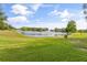 Backyard view featuring a serene pond with a fountain, surrounded by lush greenery and well-maintained lawn at 3534 Woodley Park Pl, Oviedo, FL 32765
