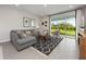 Inviting living room with a gray sofa, modern rug, and sliding glass doors to the backyard at 4409 Lions Gate Ave, Clermont, FL 34711
