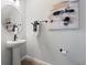 Chic powder room featuring a pedestal sink, round mirror, and modern wall art at 4409 Lions Gate Ave, Clermont, FL 34711