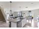 Open-concept kitchen with an island, granite countertops, stainless steel appliances, and a view of the living area at 4644 Bernard Blvd, Haines City, FL 33844
