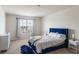 Calm, airy main bedroom featuring a plush navy bed frame, soft carpet, and a bright window at 4644 Bernard Blvd, Haines City, FL 33844
