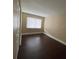 A spacious bedroom with neutral walls and dark wood-look flooring, featuring a large window with blinds at 4701 S Texas Ave # 4701A, Orlando, FL 32839