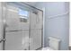 Ensuite bathroom walk-in shower stall featuring white tiles, clear glass doors and window for natural light at 4733 Cliveden Loop, Sanford, FL 32773