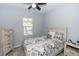 Comfortable bedroom with stylish gray bedding, light wood furniture, ceiling fan and natural light from window at 4733 Cliveden Loop, Sanford, FL 32773