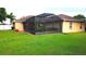 Landscaped backyard with a large screened-in patio and green grass at 4905 Newton Ct, St Cloud, FL 34771