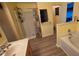 This bathroom features dual sinks, a bathtub, and separate shower with wood-look flooring at 4905 Newton Ct, St Cloud, FL 34771