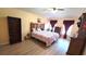 Bright bedroom features a floral bedspread, rustic headboard, and wood-look flooring at 4905 Newton Ct, St Cloud, FL 34771