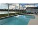 Beautiful pool with a scenic lake view, surrounded by a screened-in enclosure at 513 Bailey Cir, Davenport, FL 33897