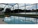 Relaxing pool with a view of the lake and blue skies at 513 Bailey Cir, Davenport, FL 33897
