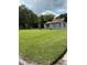 View of the home from the yard with green grass and mature trees at 524 Florida Ave, St Cloud, FL 34769