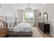 Bright bedroom features board and batten wall, large window, modern light fixture, and neutral decor at 5242 Handsome Hills Dr, Mount Dora, FL 32757
