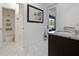 Bright bathroom with a granite countertop vanity, closet, and backyard view at 5264 Obsidian Gate Dr, Mount Dora, FL 32757