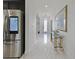 Elegant entryway with marble floors, glass console table, and a Samsung smart refrigerator in the kitchen, offering a modern touch at 5264 Obsidian Gate Dr, Mount Dora, FL 32757