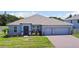 Charming single-story home featuring a well-manicured lawn, brick driveway, and a two-car garage at 5264 Obsidian Gate Dr, Mount Dora, FL 32757