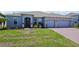 Charming single-story home featuring a well-manicured lawn, brick driveway, and a two-car garage at 5264 Obsidian Gate Dr, Mount Dora, FL 32757