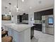 Spacious kitchen featuring a large island with granite countertops, dark cabinets, stainless steel appliances and bar stool seating at 5264 Obsidian Gate Dr, Mount Dora, FL 32757
