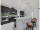 Chef's kitchen features a large island, dark cabinetry, stainless steel appliances, and white marble floors at 5264 Obsidian Gate Dr, Mount Dora, FL 32757