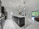 Open kitchen with dark cabinets, a large island with granite countertop, and modern pendant lighting, perfect for entertaining at 5264 Obsidian Gate Dr, Mount Dora, FL 32757