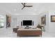 Modern living room with a dark ceiling fan, neutral sofas, and art, offering a comfortable space for relaxation at 5264 Obsidian Gate Dr, Mount Dora, FL 32757