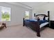Bedroom featuring a dark wood bed frame with a blue comforter and decorative pillows at 5264 Obsidian Gate Dr, Mount Dora, FL 32757