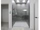 Modern shower features stylish gray tiling, rainfall shower head, and glass door at 5264 Obsidian Gate Dr, Mount Dora, FL 32757