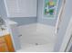 A corner soaking tub is set below a shuttered window in this bathroom at 5353 Red Leaf Ct, Oviedo, FL 32765