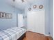 Bedroom with light blue walls, wood floors, ceiling fan, and a double door closet at 5353 Red Leaf Ct, Oviedo, FL 32765