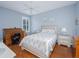 Comfortable bedroom with a ceiling fan, hardwood floors, light blue walls, and shuttered windows at 5353 Red Leaf Ct, Oviedo, FL 32765