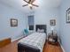Cozy bedroom featuring light blue walls, wood floors, a ceiling fan, and comfortable furnishings at 5353 Red Leaf Ct, Oviedo, FL 32765