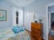 Bedroom featuring hardwood floors, a large window with curtains, and a wooden dresser at 5353 Red Leaf Ct, Oviedo, FL 32765