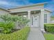 Close-up of a covered front porch with decorative plants and shrubs around the entrance at 5353 Red Leaf Ct, Oviedo, FL 32765