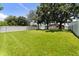 Spacious backyard featuring lush green grass, mature trees, and a white privacy fence at 5451 Los Palma Vista Dr, Orlando, FL 32837
