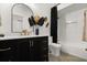 Stylish bathroom featuring a black vanity, elegant gold hardware, and a tub with shower at 5451 Los Palma Vista Dr, Orlando, FL 32837
