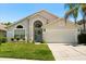 Charming single-Gathering home featuring a well-manicured lawn, a two-car garage, and an arched entryway at 5451 Los Palma Vista Dr, Orlando, FL 32837