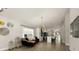 Bright living space with herringbone floors, modern lighting, and seamless flow to the kitchen at 5451 Los Palma Vista Dr, Orlando, FL 32837