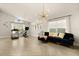 Open-concept living room with modern lighting, neutral decor, and herringbone flooring at 5451 Los Palma Vista Dr, Orlando, FL 32837