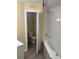 Bathroom featuring a tub with tiled wall, gray plank flooring, and a toilet closet at 5821 La Costa Dr # 108, Orlando, FL 32807