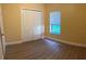 Bedroom featuring a window, new gray flooring, and a closet for optimal storage at 5821 La Costa Dr # 108, Orlando, FL 32807