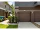 Attached garage of a townhome featuring a brown door and driveway at 6566 S Goldenrod Rd # 82A, Orlando, FL 32822