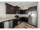 Well-equipped kitchen features stainless steel appliances, dark wood cabinets, and wood-look flooring at 6566 S Goldenrod Rd # 82A, Orlando, FL 32822