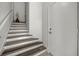 Staircase leading to upper level featuring wood and white accents, with a white door at 6566 S Goldenrod Rd # 82A, Orlando, FL 32822